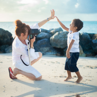 Christine high-fiving a child during a beach session
