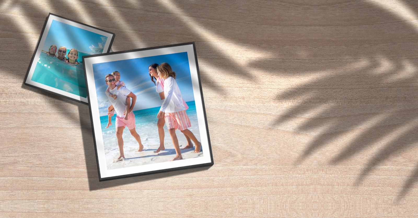 Two framed Paradise Photography prints resting on a wooden table
