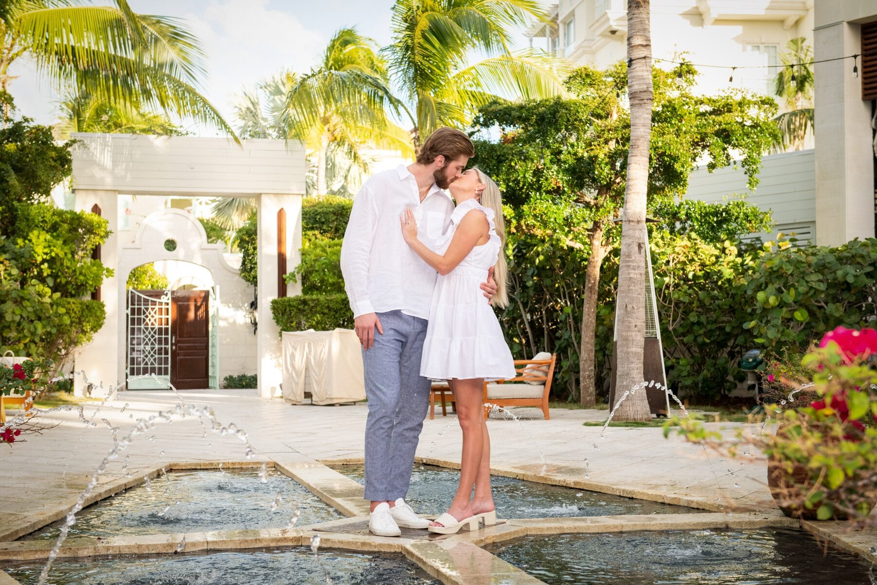 Couple kissing beside a courtyard fountain at a Turks and Caicos resort