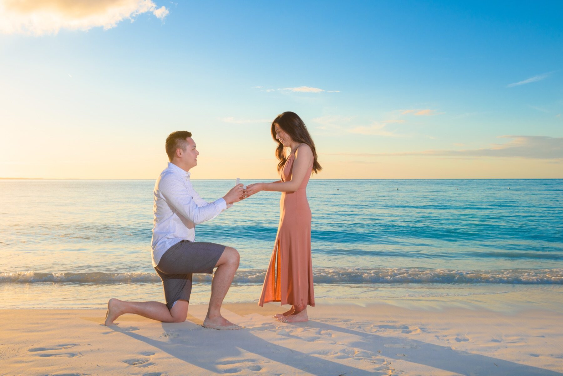 Man on one knee proposing at golden hour on a Turks and Caicos beach