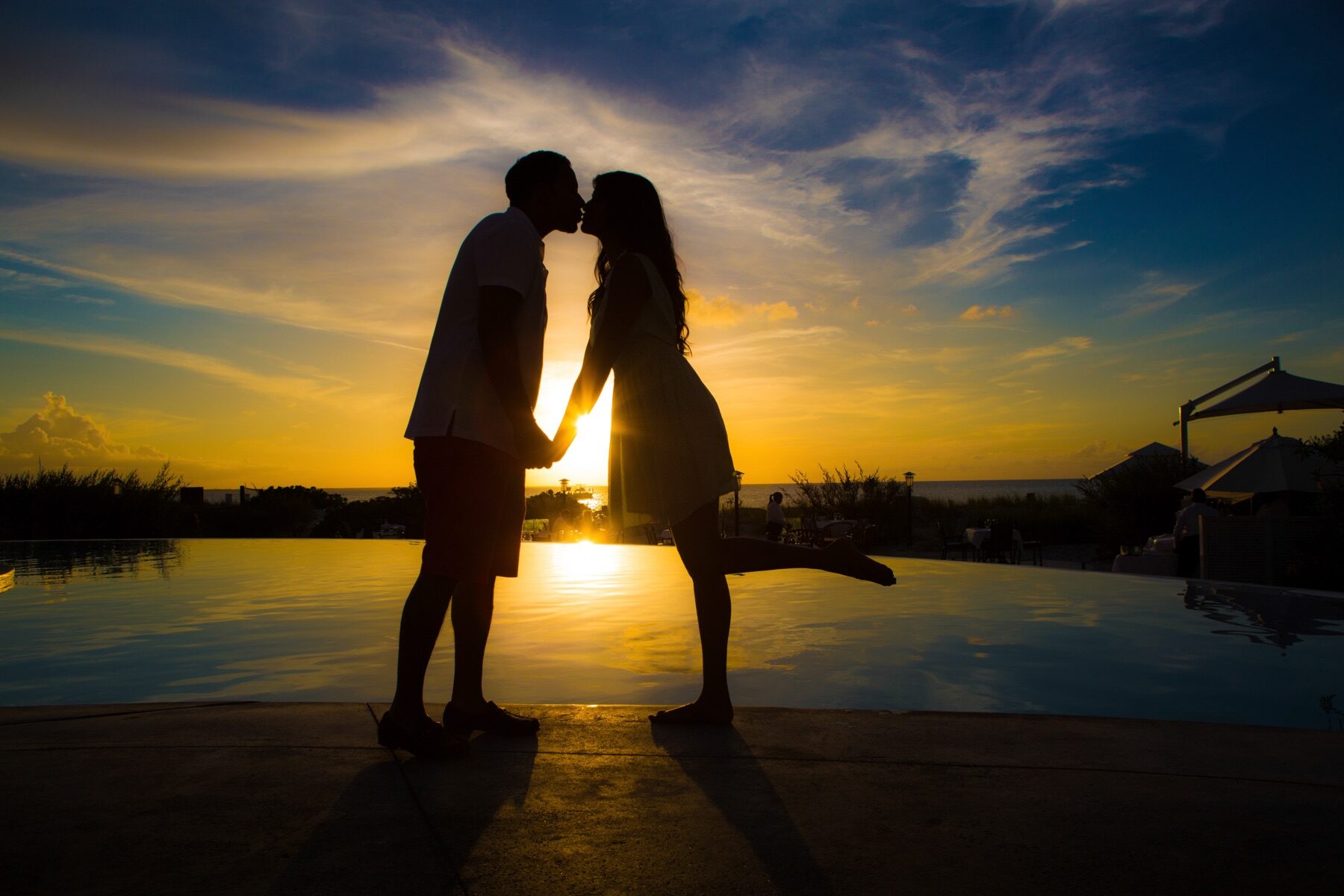 Silhouette of a couple kissing poolside in front of a Turks and Caicos sunset