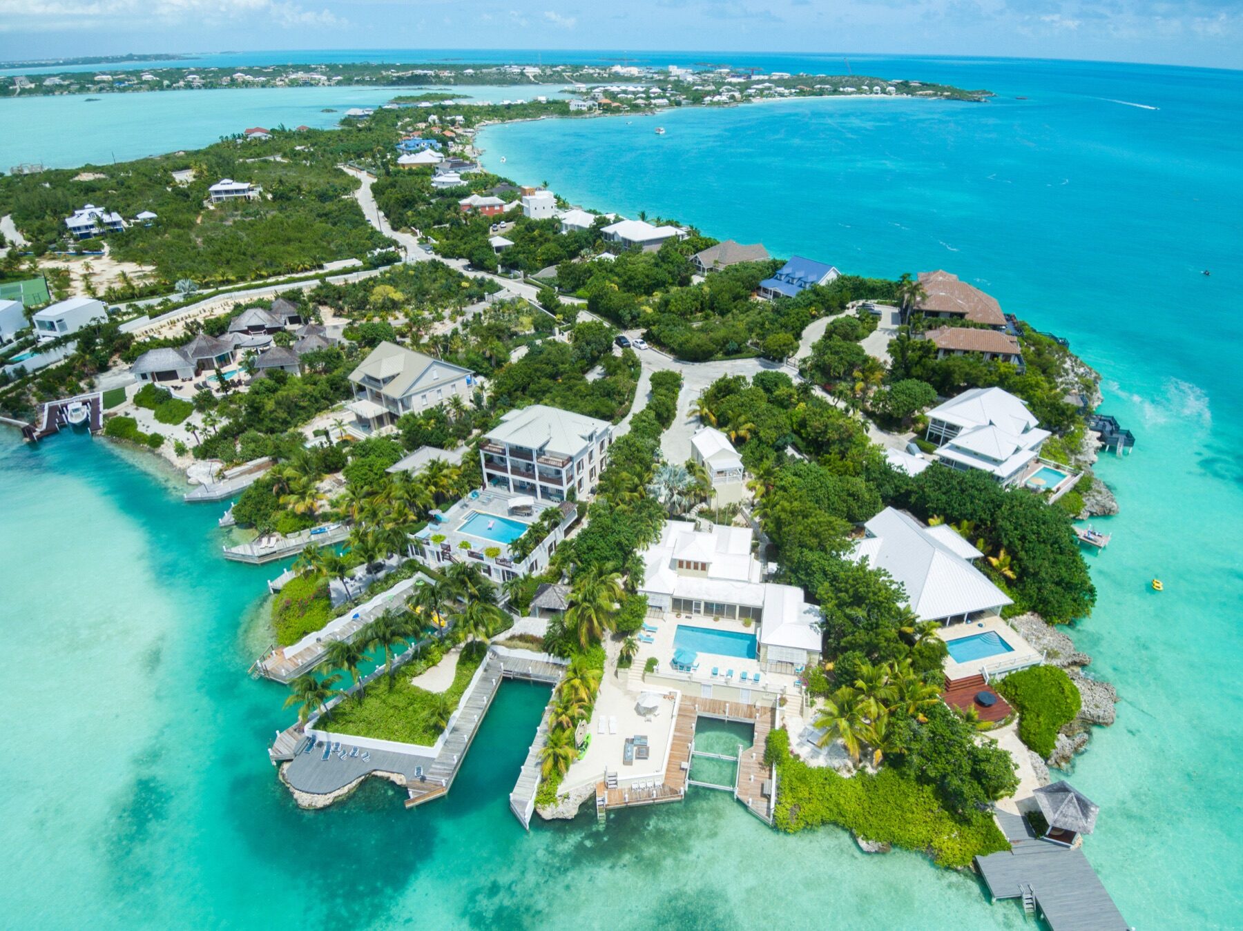 Aerial view of a coastal peninsula lined with private villas and pools