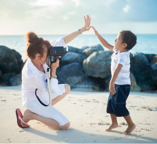 Photographer high-fiving a young boy during a beach session