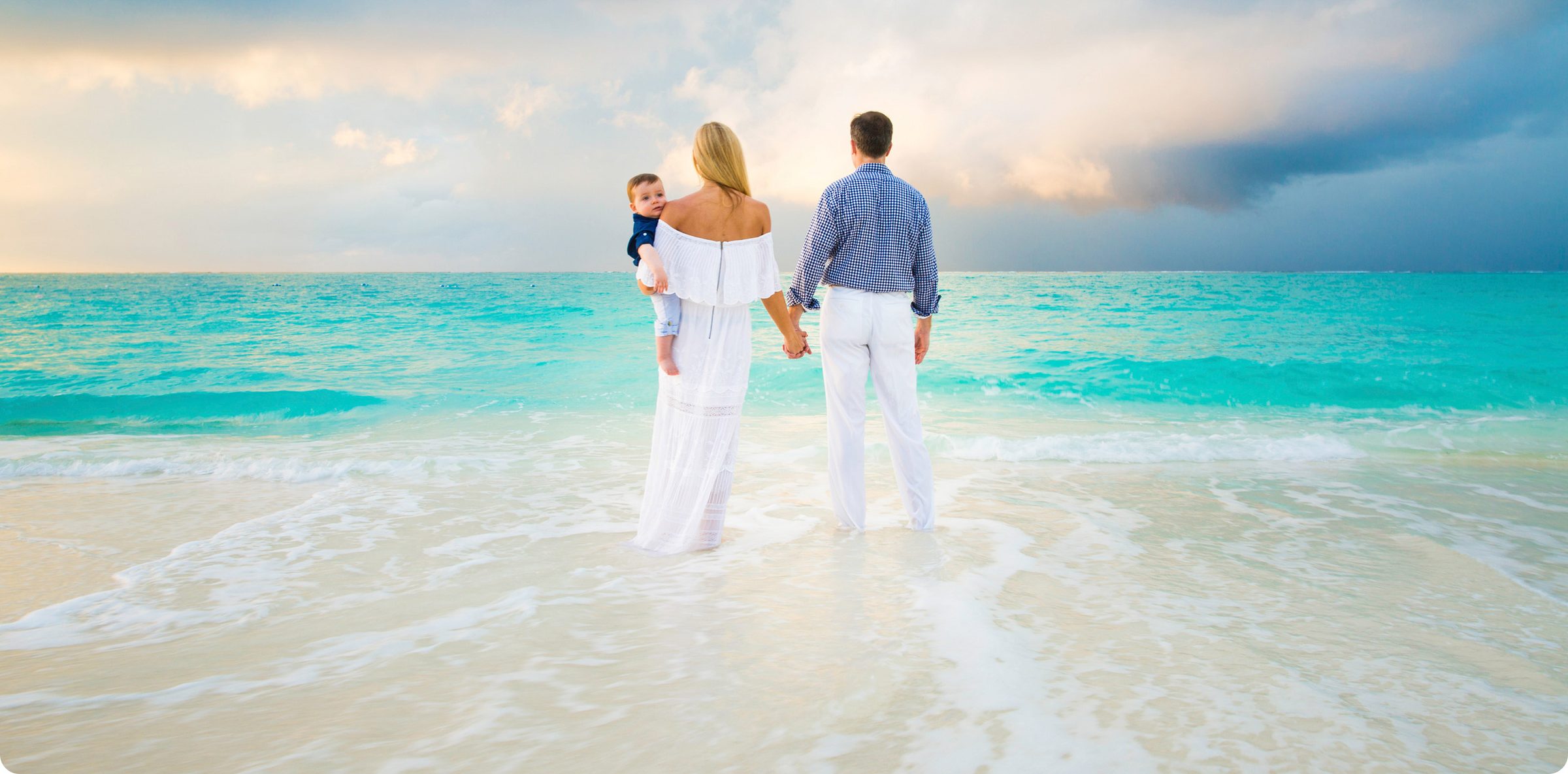 Family running on the beach at sunset