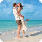 Couple embracing on the beach, the man lifting his partner